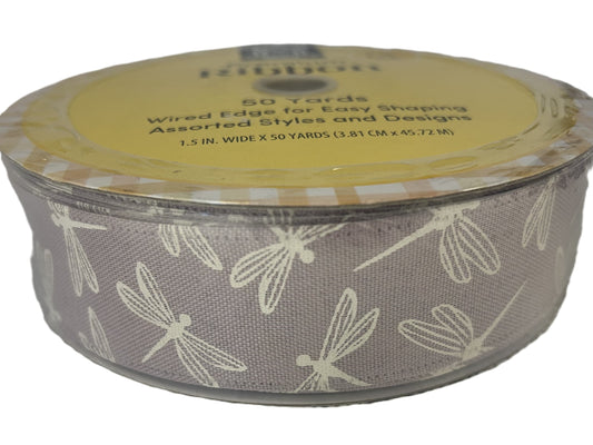 Spool of ribbon with dragonfly pattern on a white background