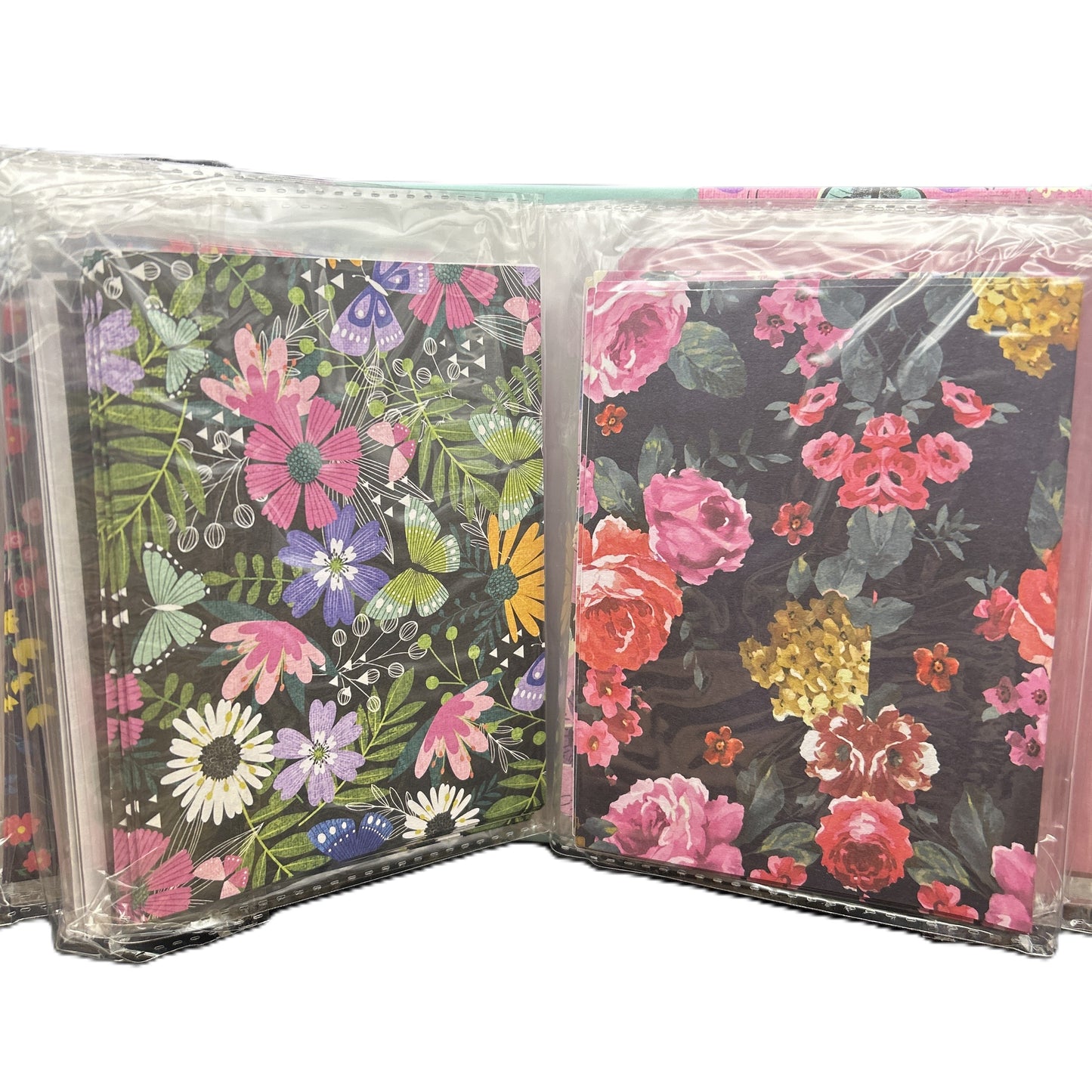 Floral and butterfly patterned notebooks in clear packaging