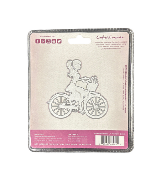 Metal die cut of a girl on a bicycle with packaging on a white background