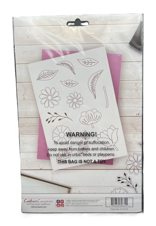 Floral design stencils in a packaging box on a wooden surface
