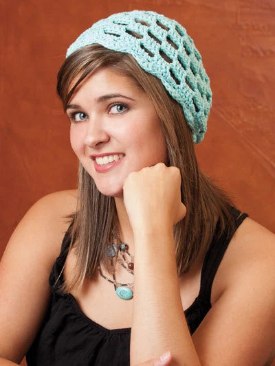 Woman wearing a teal knitted hat against a brown background