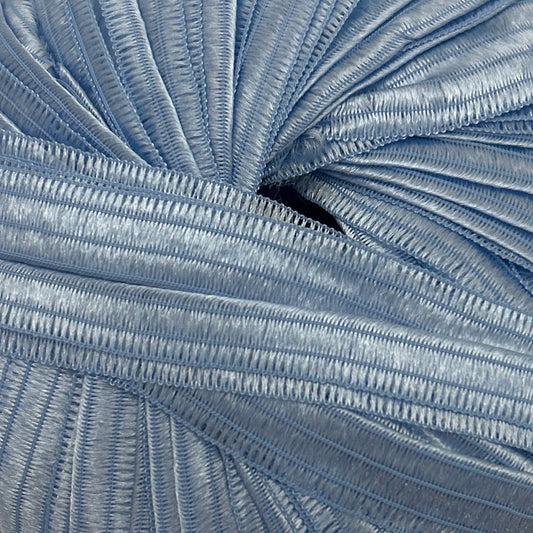 Blue skein of yarn on a beige surface