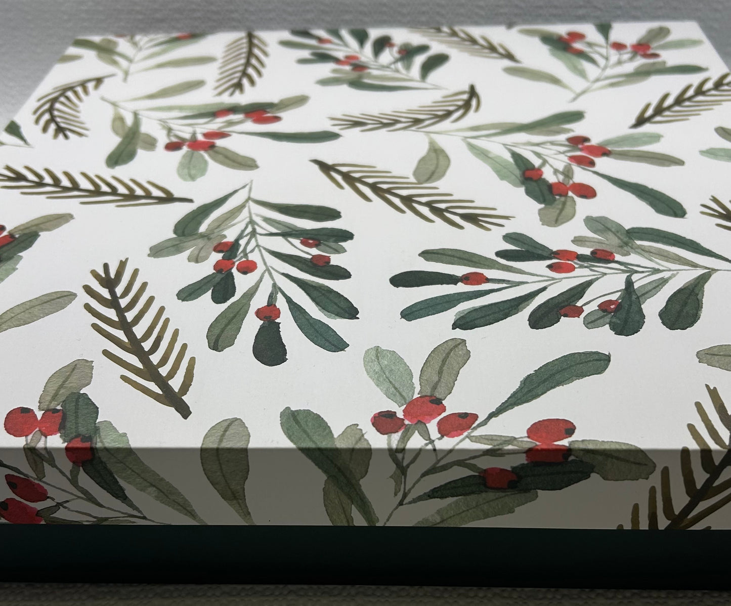 Wrinkled paper with holly leaf and berry pattern on a white background