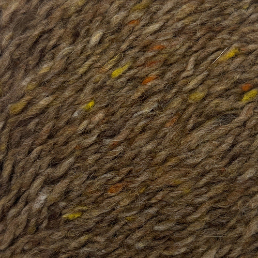 Close-up of brown fabric with small colorful specks