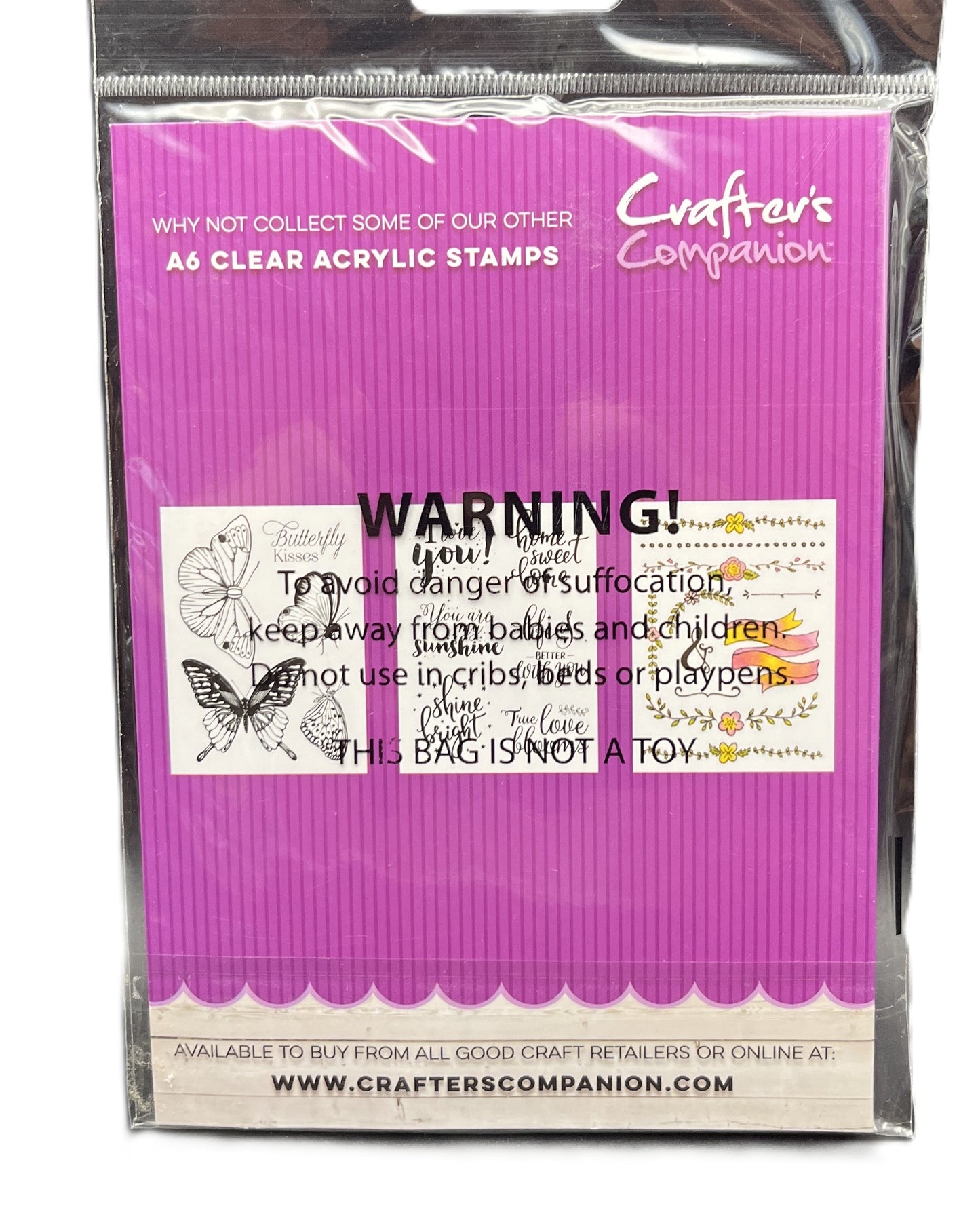Packaged clear acrylic stamps with warning label on purple background