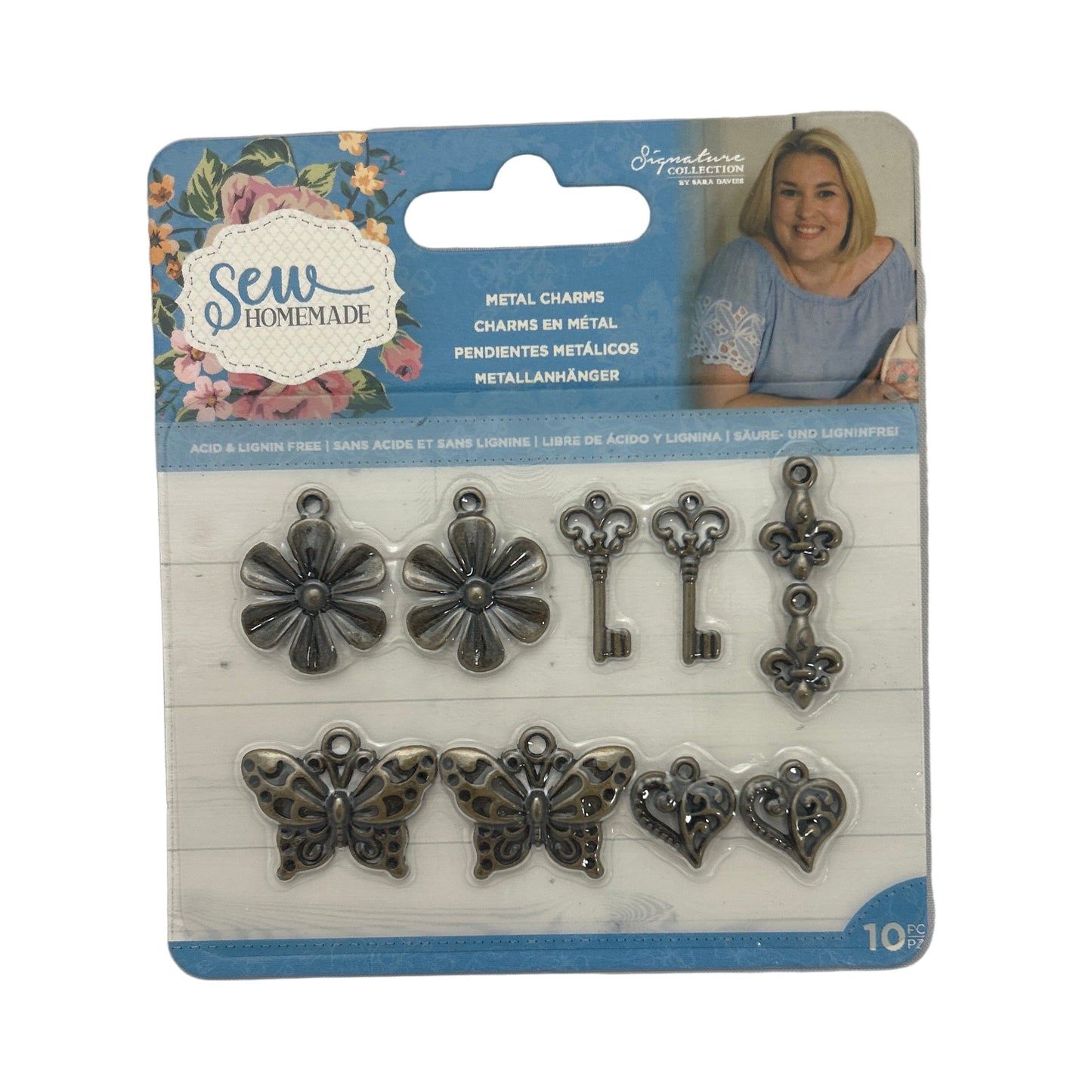 Packaged metal charms including flowers, keys, and butterflies on a white background.
