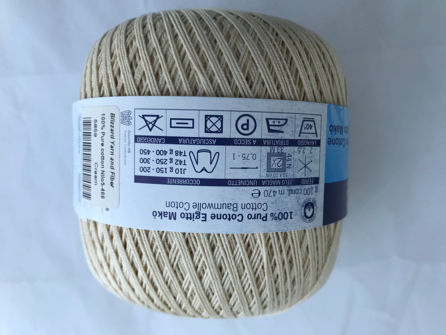 Ball of beige yarn with a label on a white background