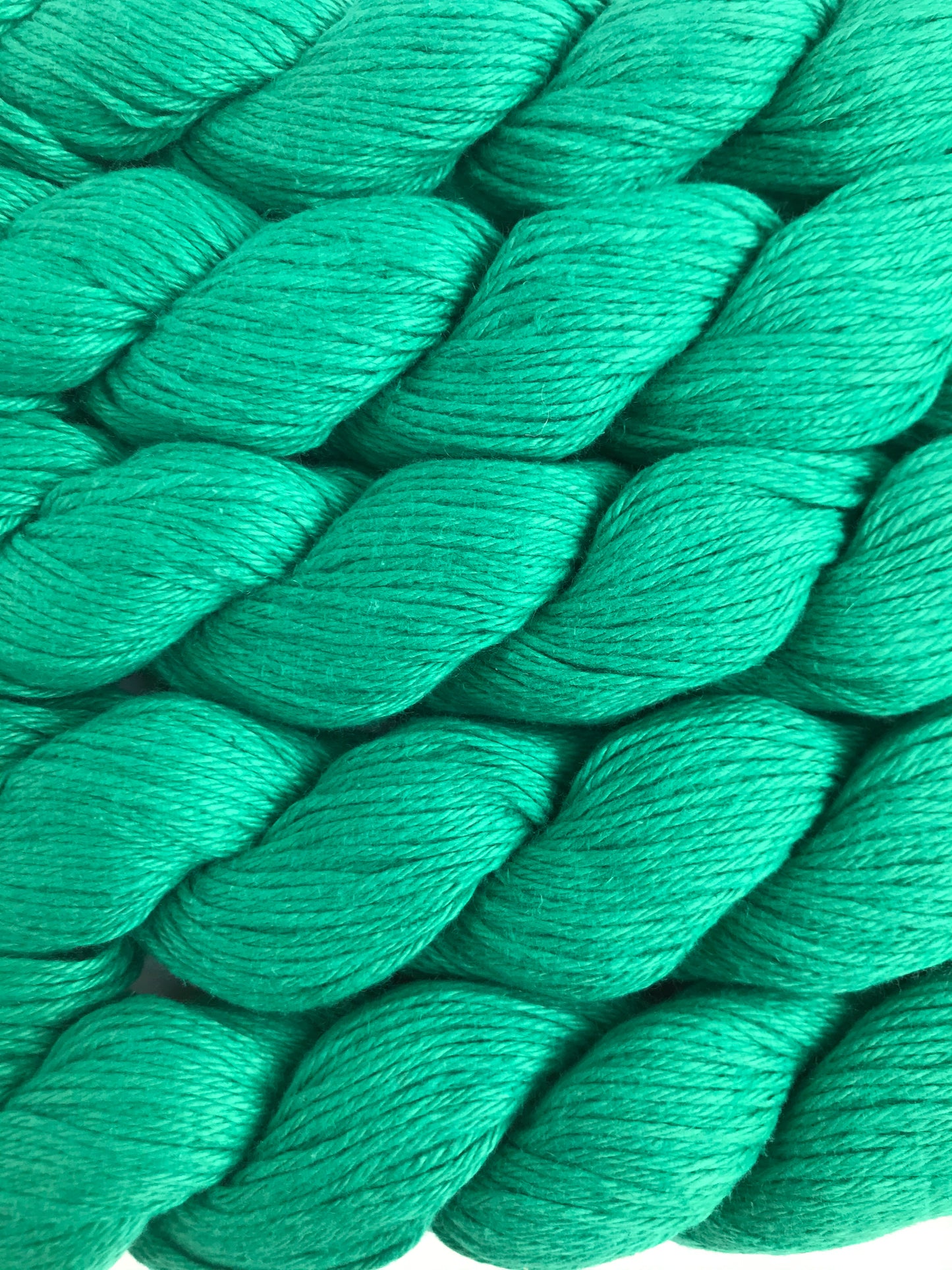 Close-up of green yarn skeins on a white background