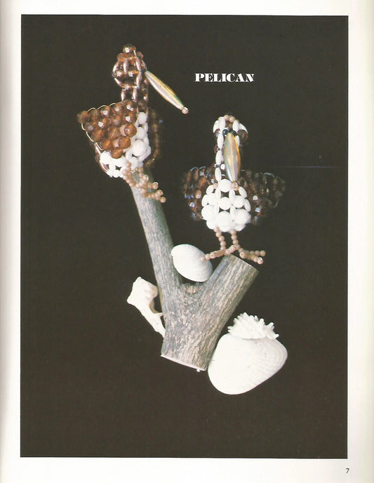 Jewelry set with pelican design on a branch against a black background