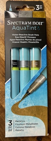 A three-pack of Spectrum Noir AquaTint water-reactive brush pens in a metallic color set.