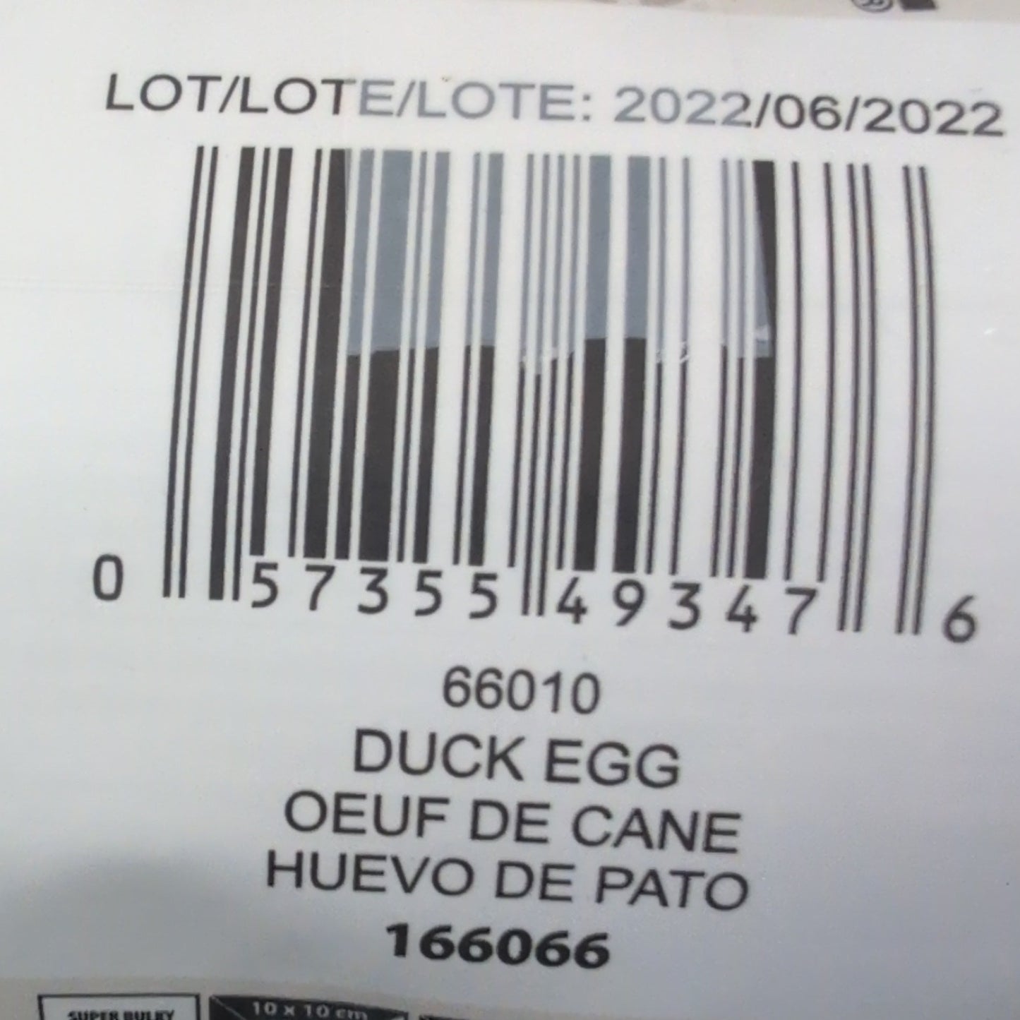 Close-up of a duck egg carton with a barcode and text on a wooden surface