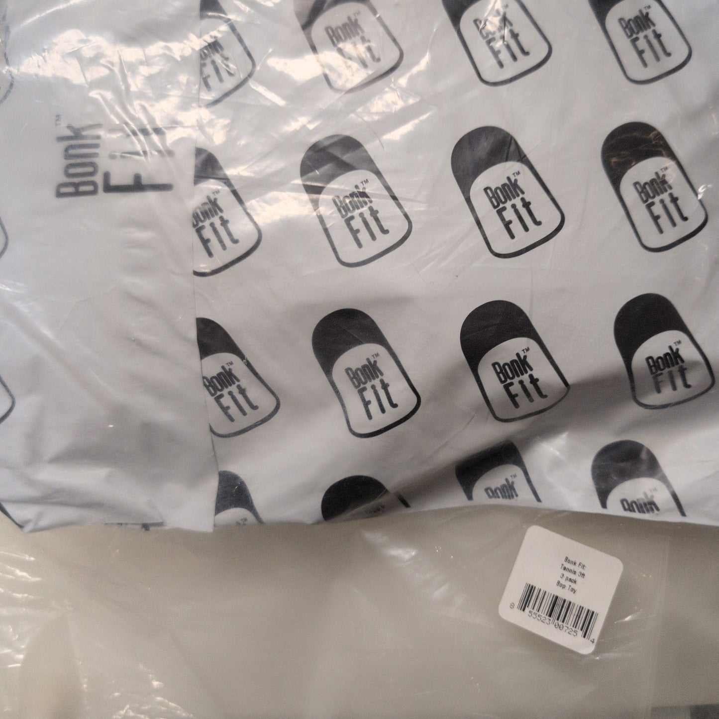 White product with black branding labels on a clear plastic bag.