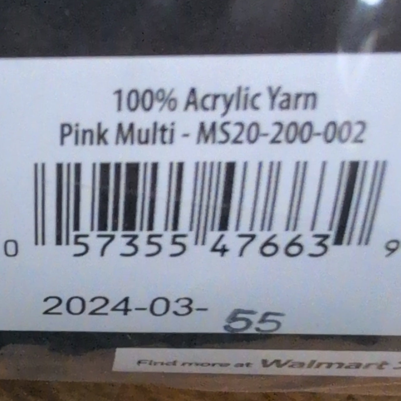 Close-up of a label on a package with text and a barcode, placed on a wooden surface.