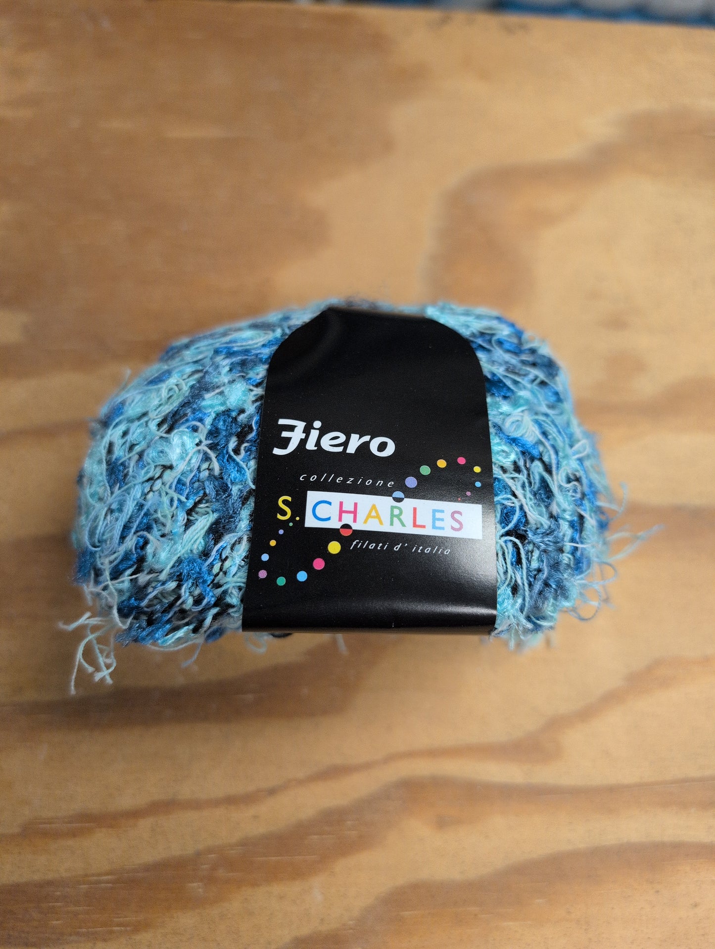 Blue yarn ball with a label on a wooden surface