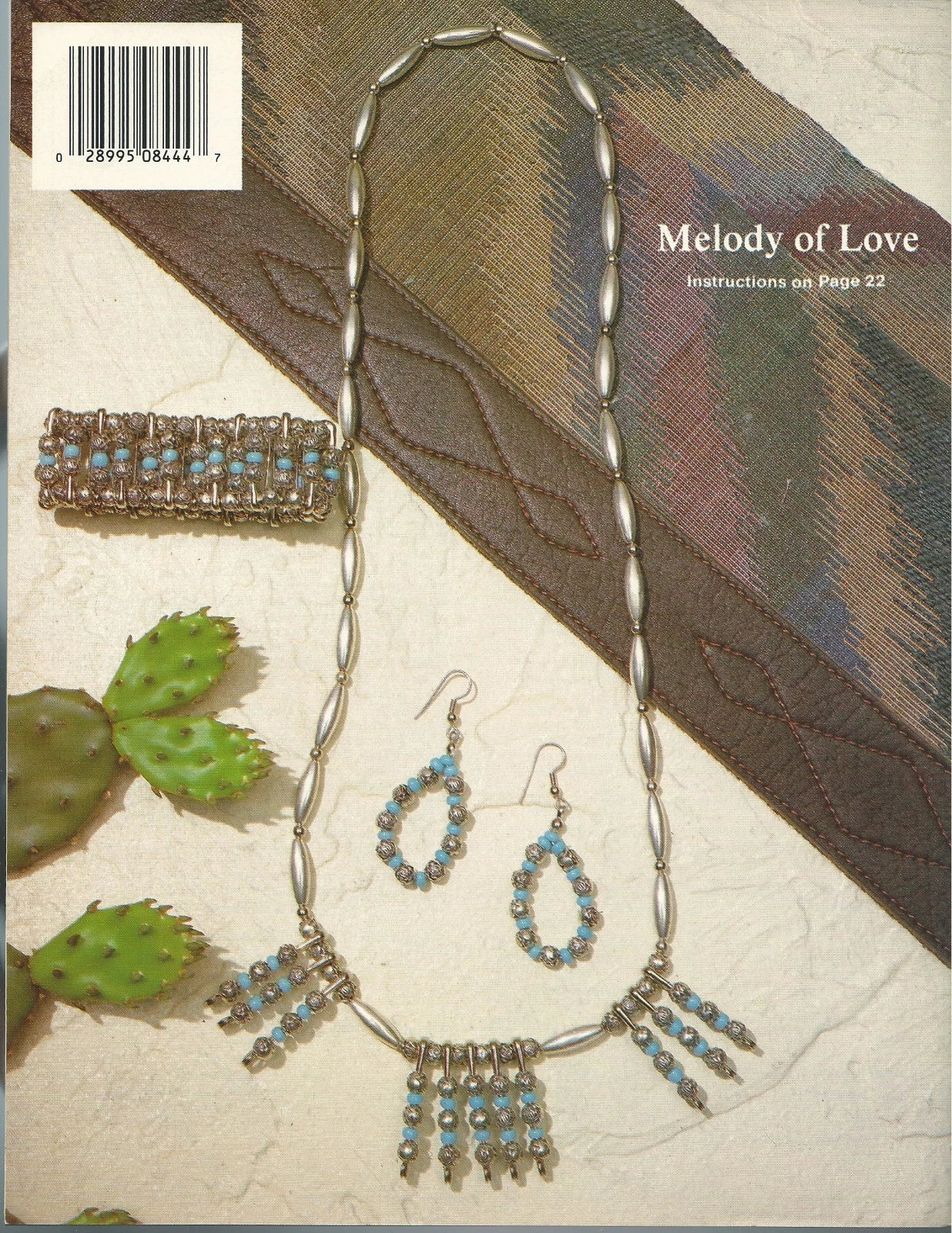 Jewelry set with necklace, earrings, and bracelet on a textured surface with cactus illustration.