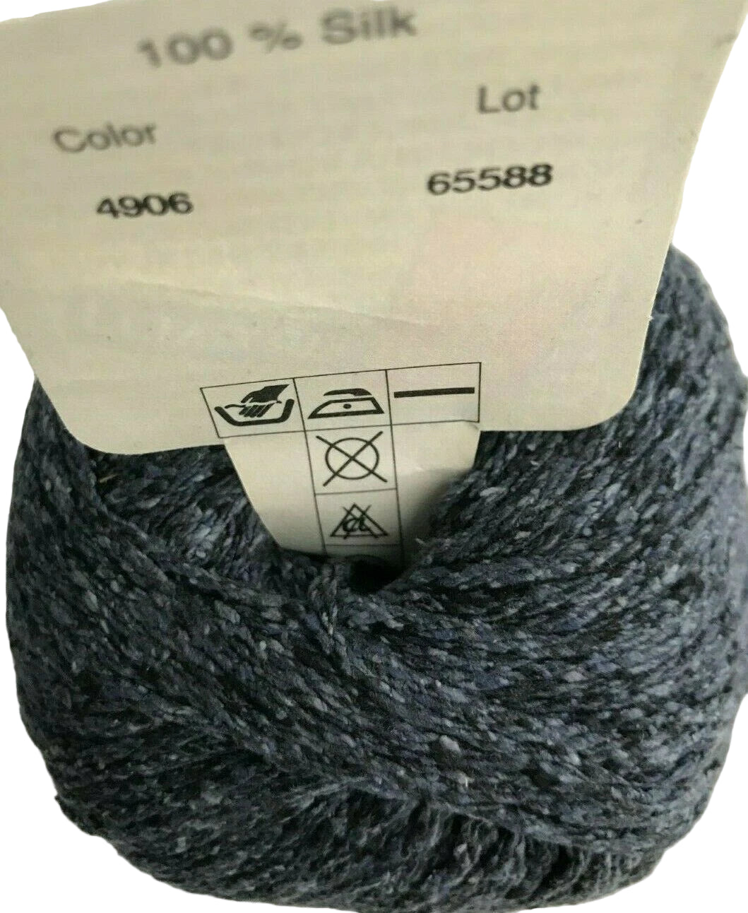 Ball of gray yarn with a label showing fabric information.