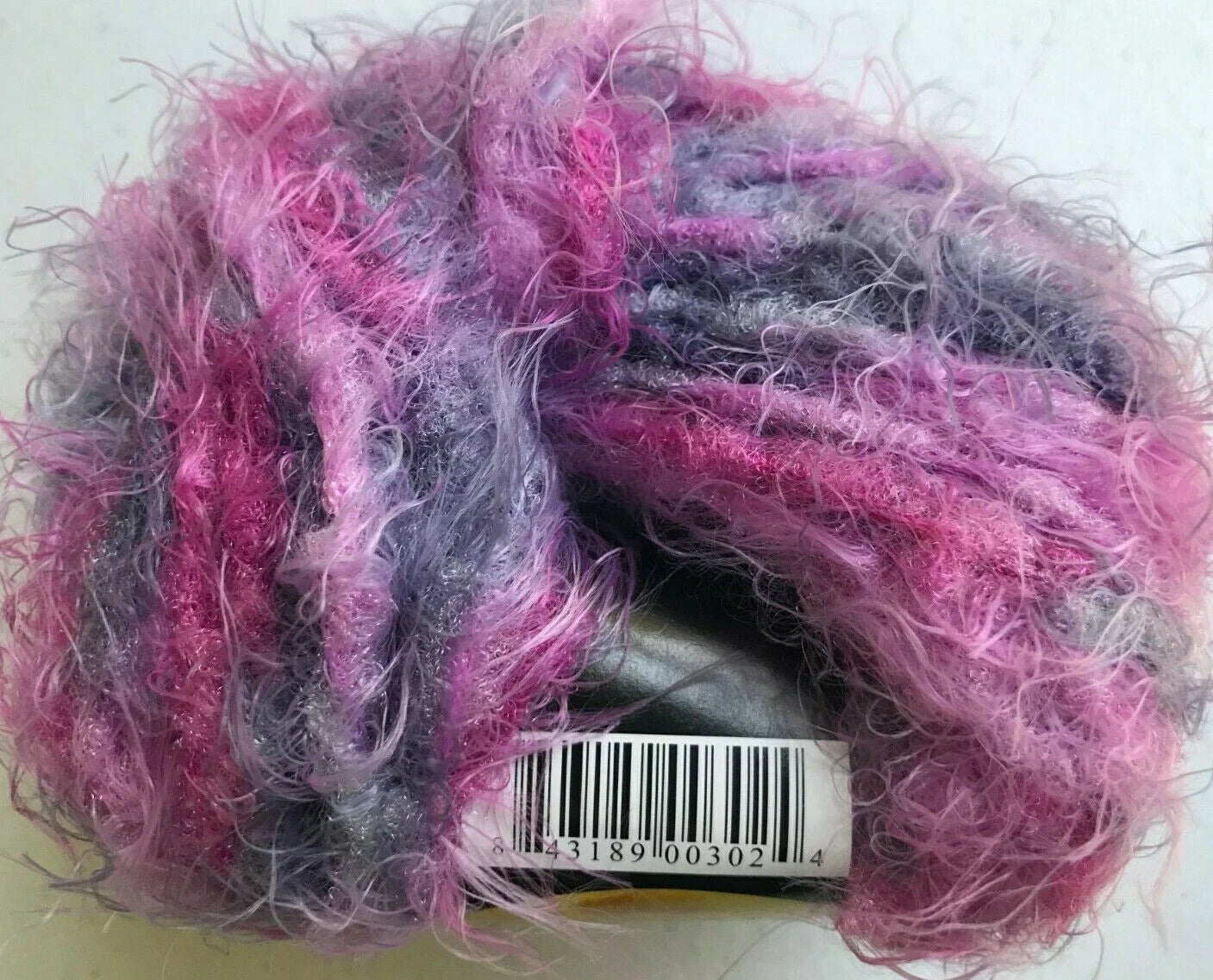 Ball of pink and gray yarn with a barcode label on a white background