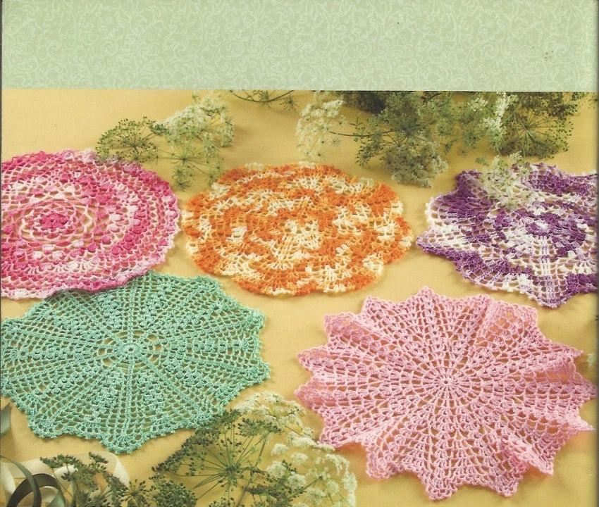 Yarn pattern book cover with crocheted doilies in various colors on a green background