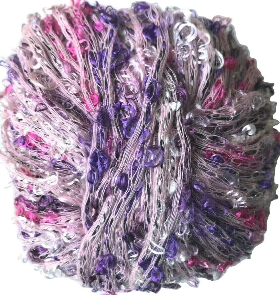 Close-up of a ball of yarn with purple, pink, and silver accents on a white background