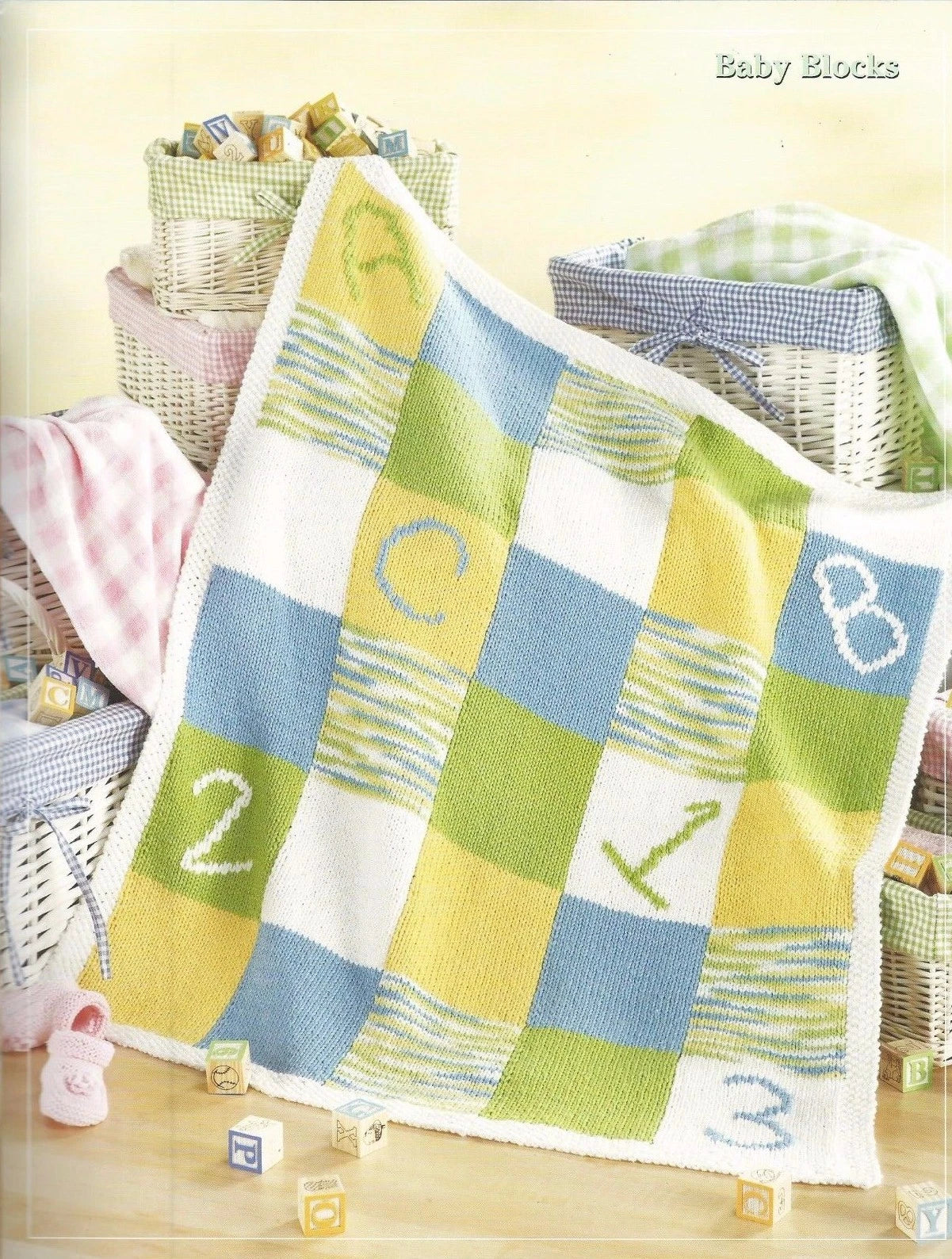 Baby blanket with alphabet and number patterns on a wooden floor.