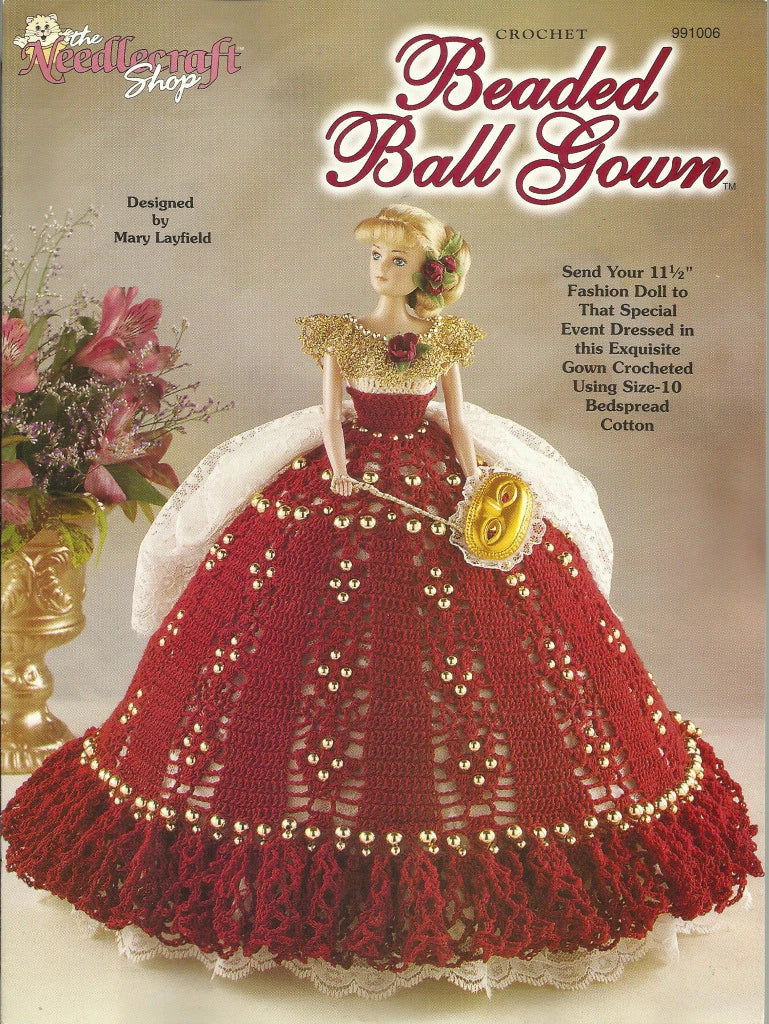 Crocheted beaded ball gown for a fashion doll on a magazine cover with text and floral decorations.