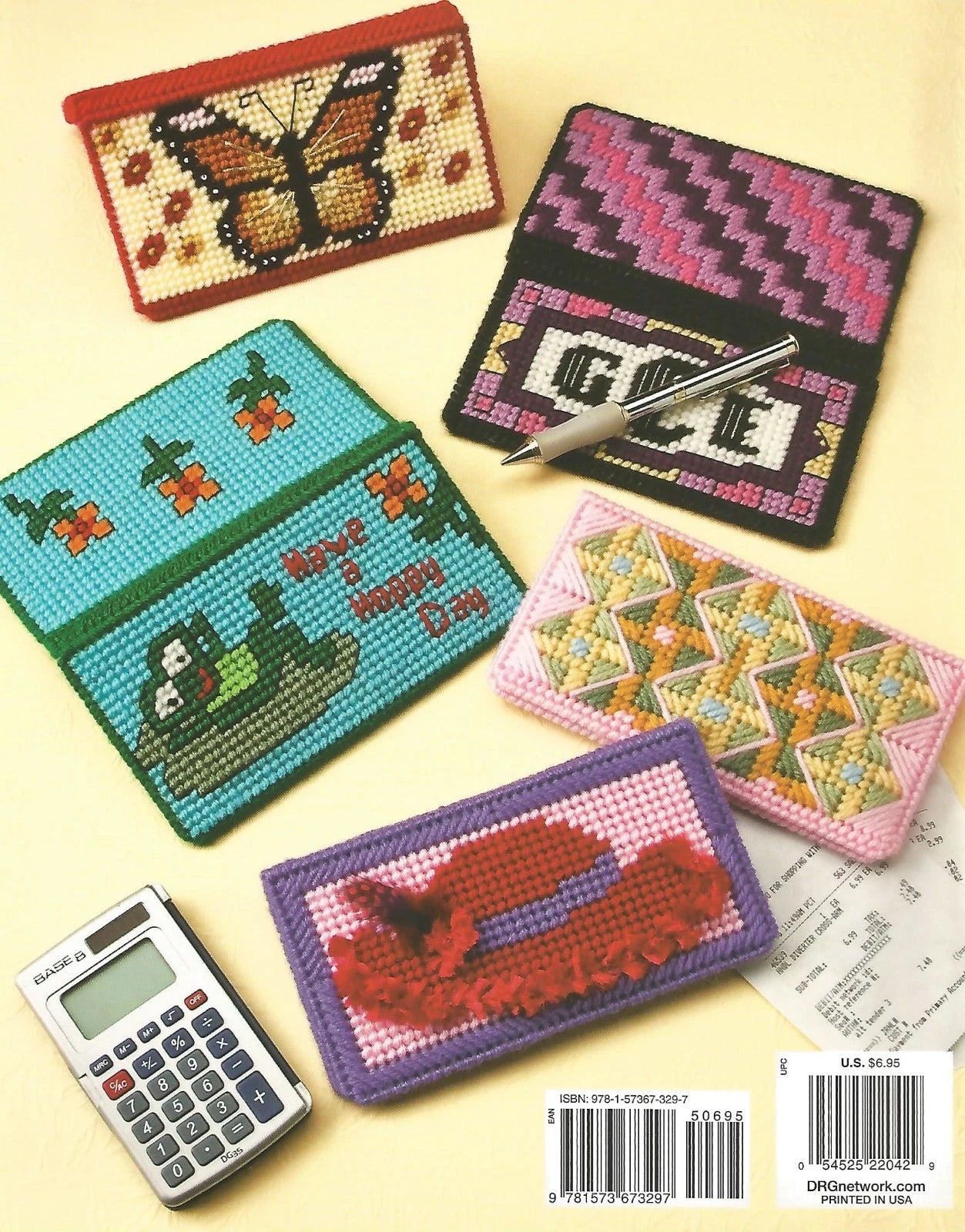 Collection of cross-stitched pouches with various designs on a yellow background, alongside a calculator.