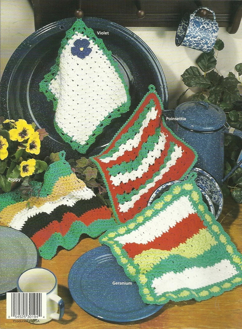 Set of crocheted dishcloths with floral and striped patterns on a table with mugs and flowers.