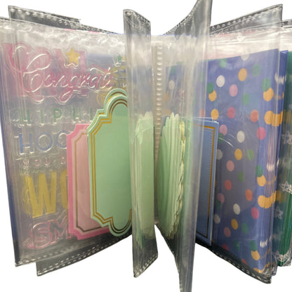 Collection of colorful greeting cards in clear plastic sleeves on a dark surface