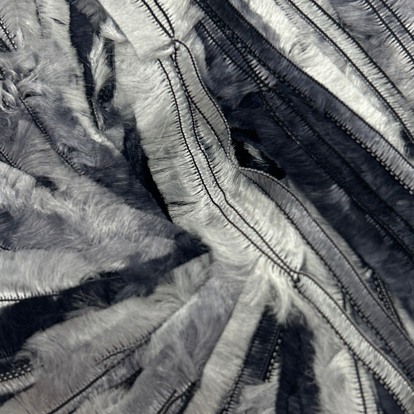 Black and silver striped fabric ball on a white background