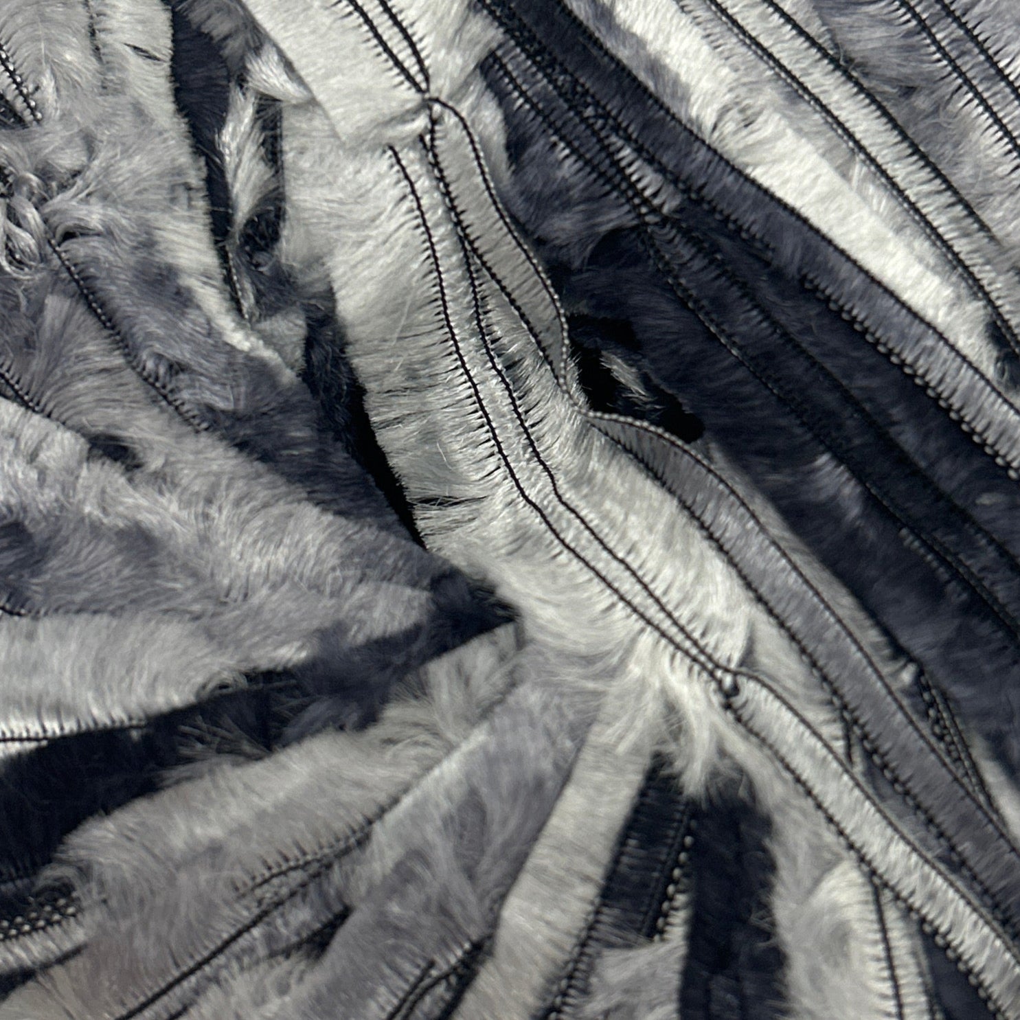 Black and silver striped fabric ball on a white background