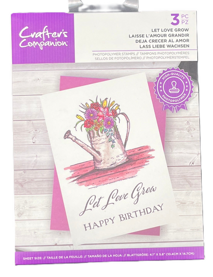 Packaging of a card with 'Let Love Grow' and 'Happy Birthday' text, featuring a watering can illustration.