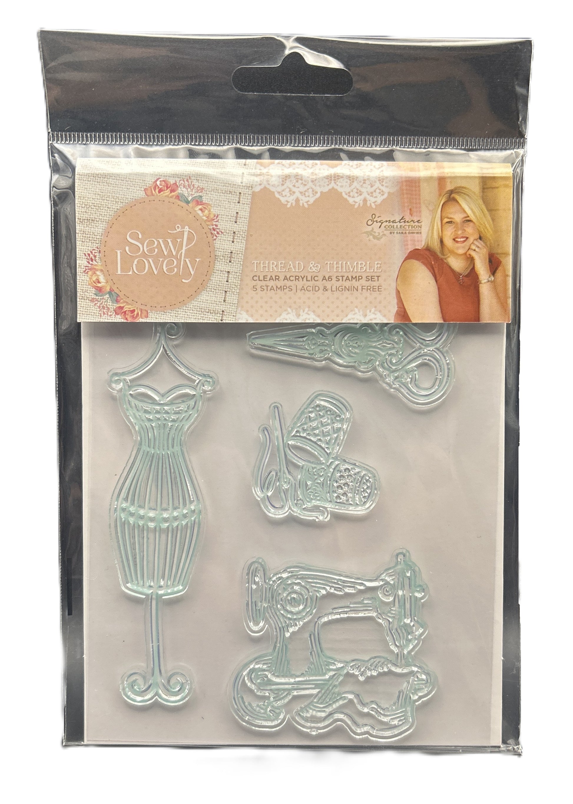 Clear acrylic stamp set with sewing-themed designs in a clear plastic packaging.