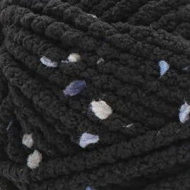 Black yarn ball with confetti pattern and Bernat label on a white background