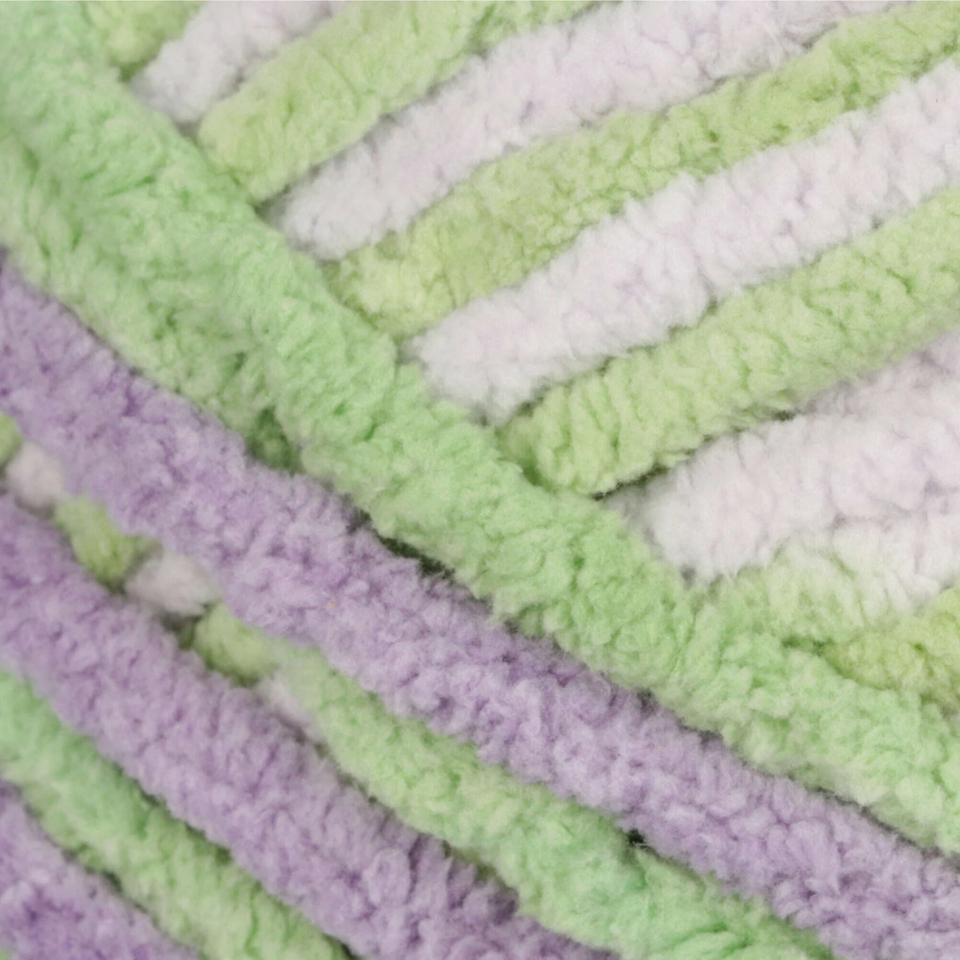 Close-up of textured fabric with green, white, and purple stripes.