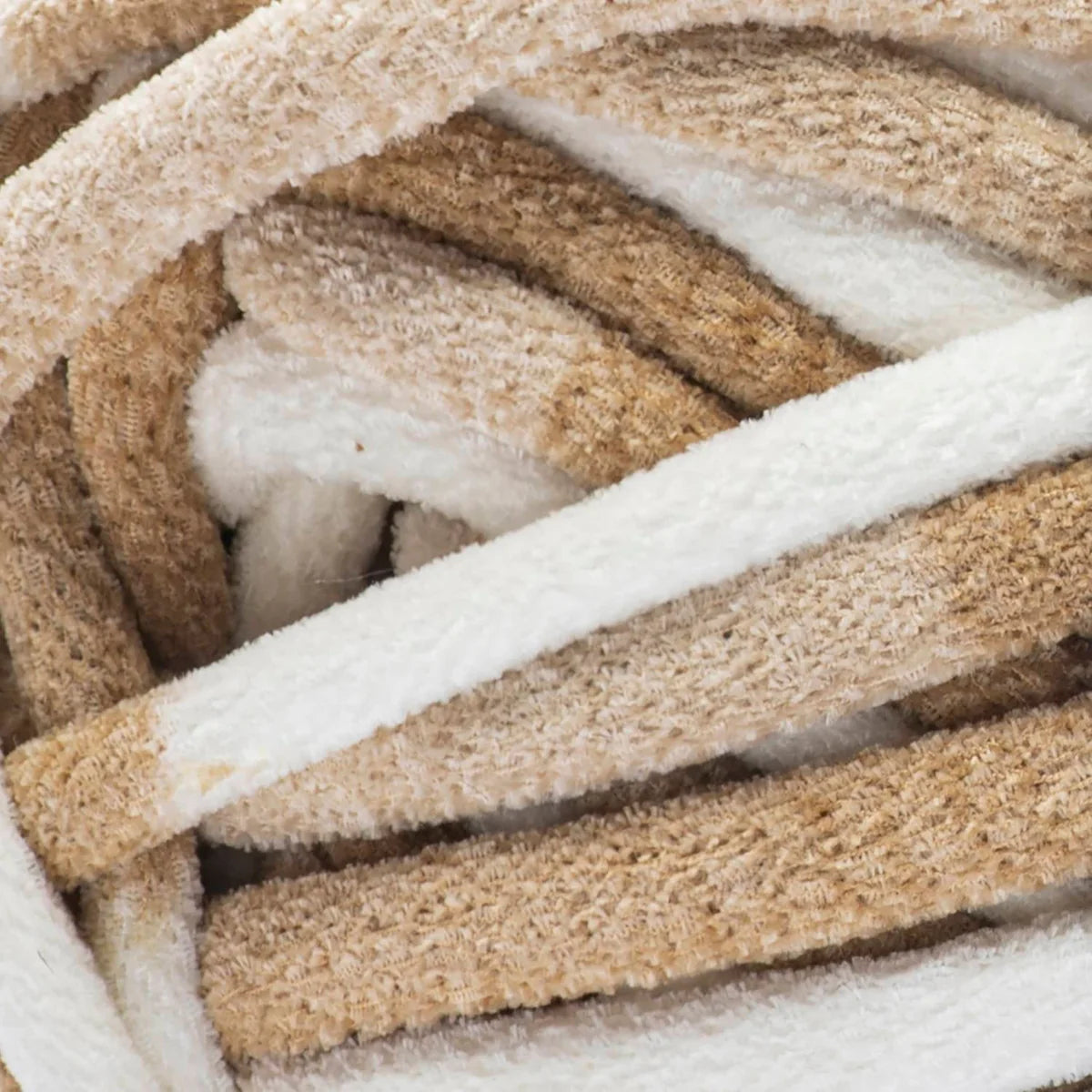 Close-up of a ball of yarn with beige, brown, and white colors.