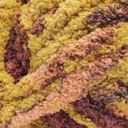 Close-up of multicolored yarn with shades of green, brown, and pink.