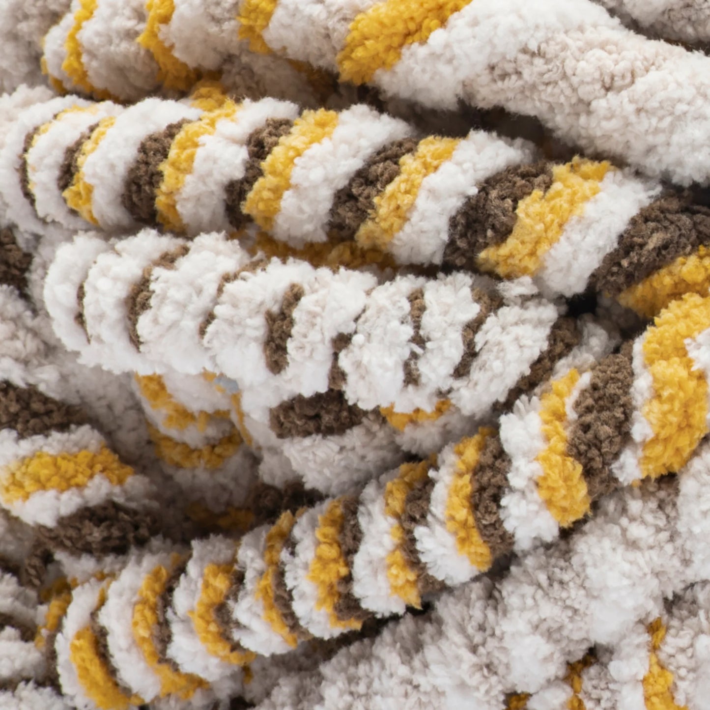 Close-up of a textured fabric with brown, yellow, and white pattern