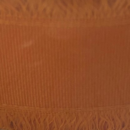 Close-up of a textured orange fabric with frayed edge
