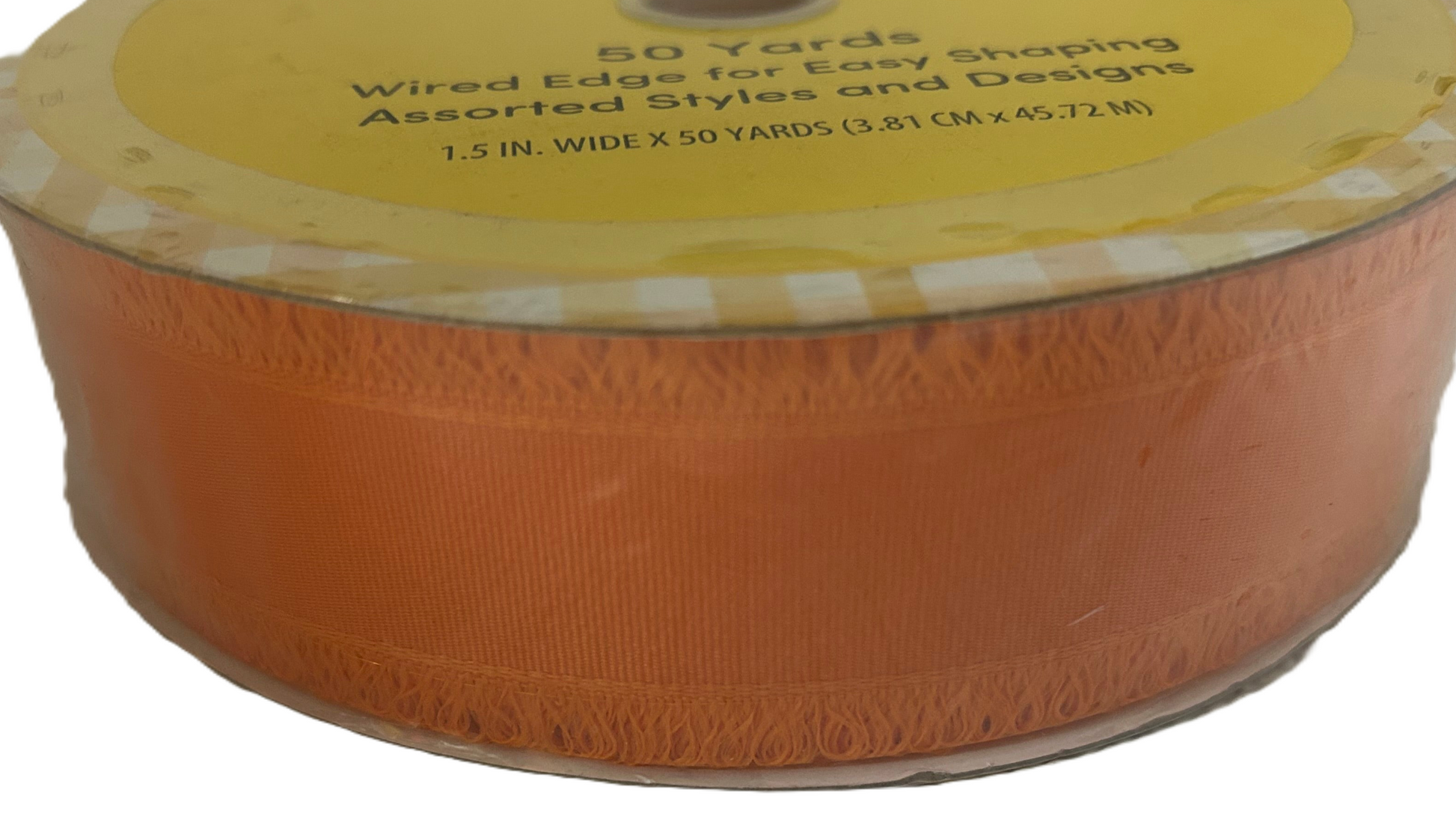 Spool of orange ribbon with a yellow label on a white background