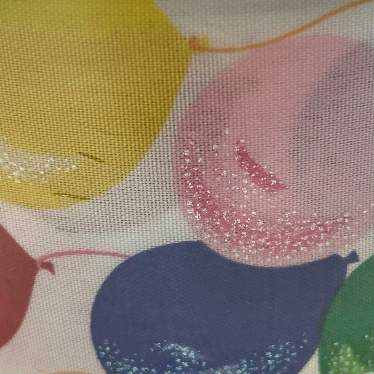 Close-up of colorful balloons with glittery accents on a fabric background