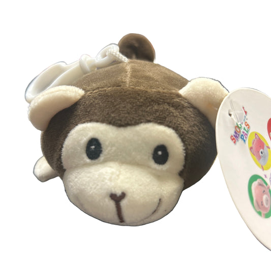 Plush monkey toy with a tag on a dark surface