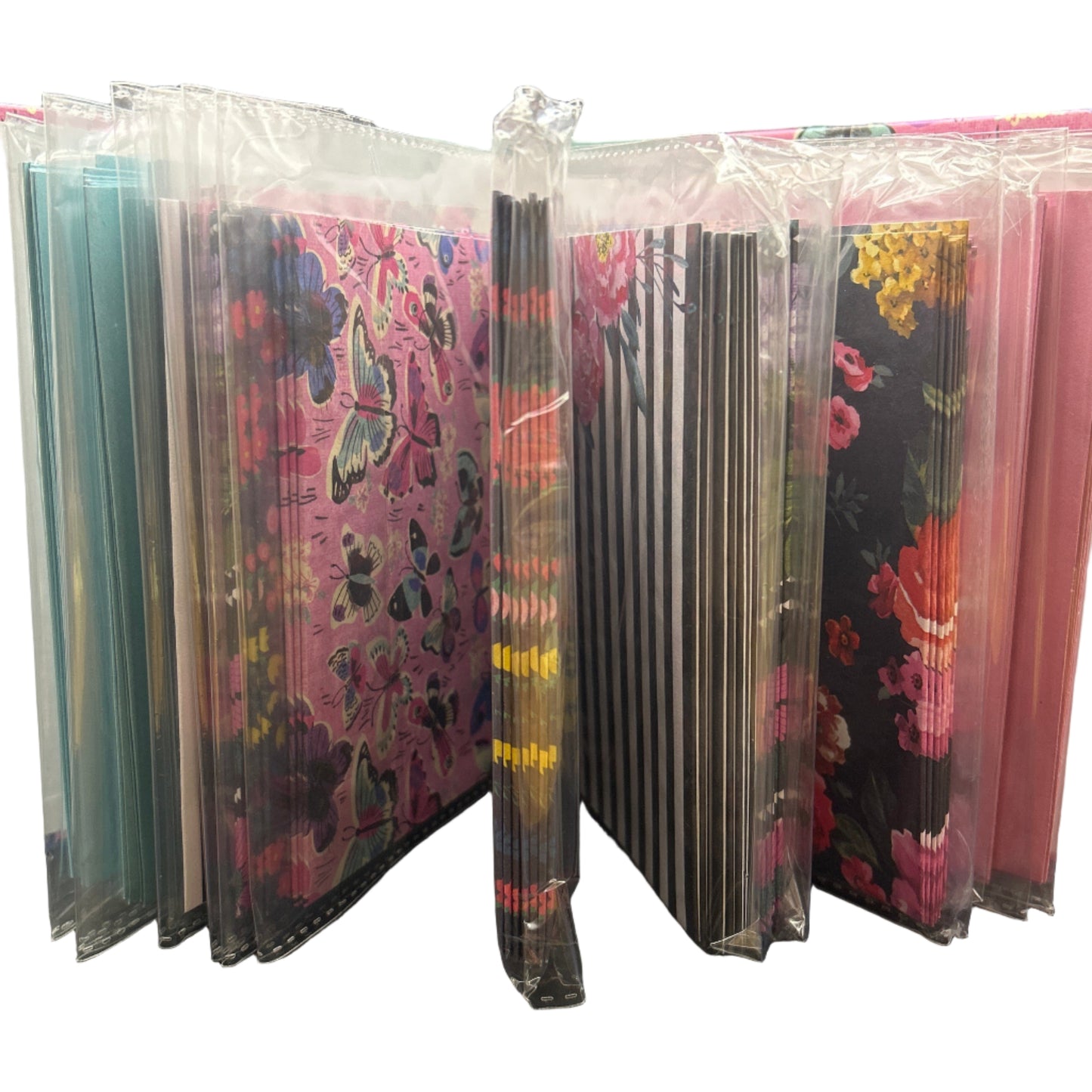 Stack of colorful books or notebooks with floral patterns on a gray surface