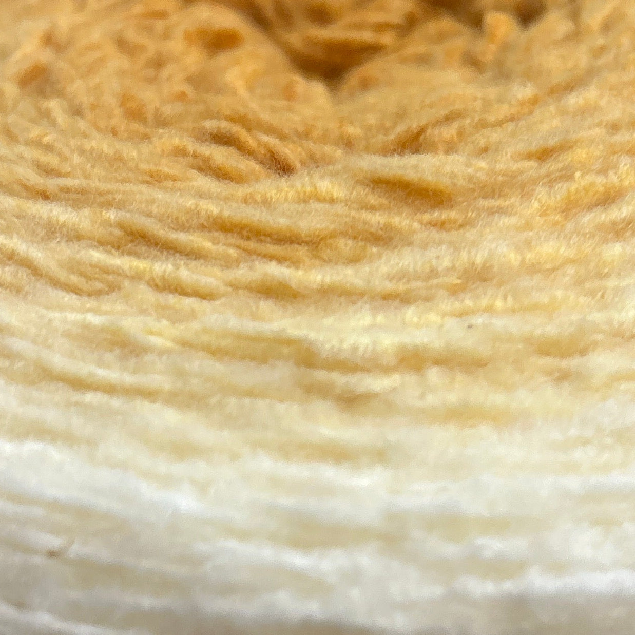 Roll of yarn with Caron label on a wooden surface
