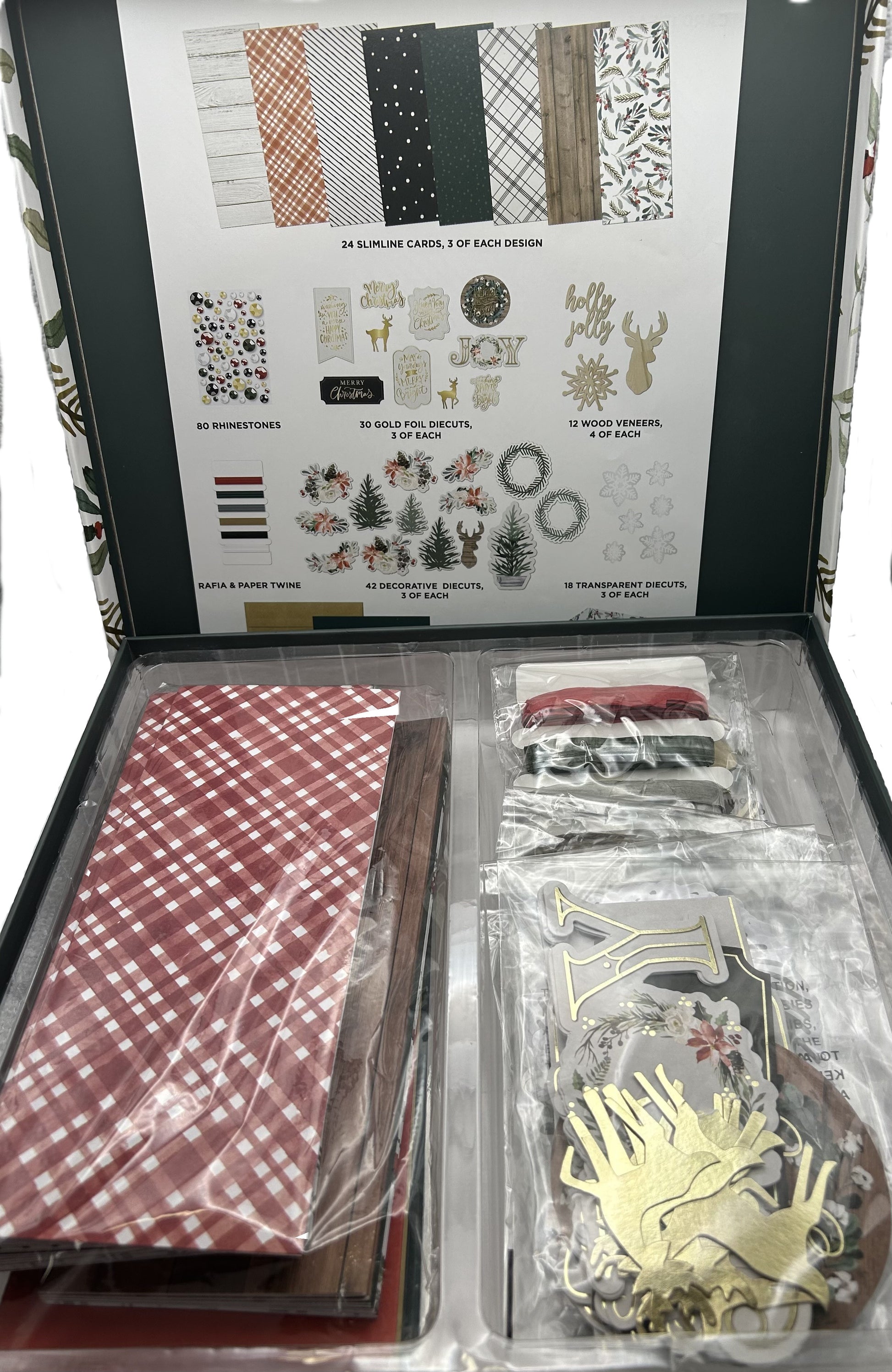 Crafting kit with patterned paper, stickers, and decorative elements in an open box.
