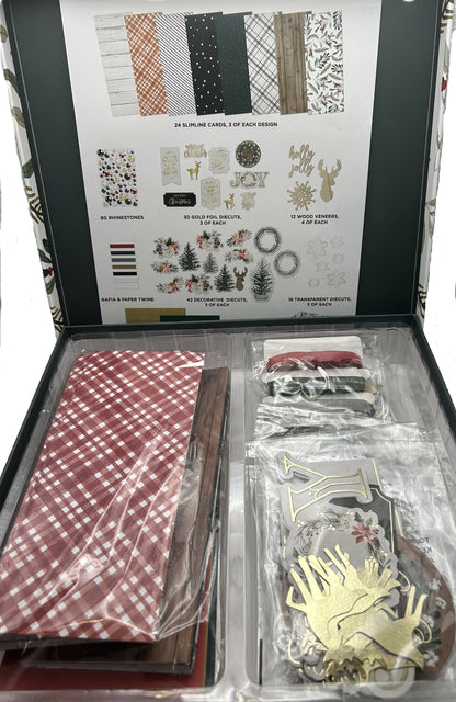 Crafting kit with patterned paper, stickers, and decorative elements in an open box.