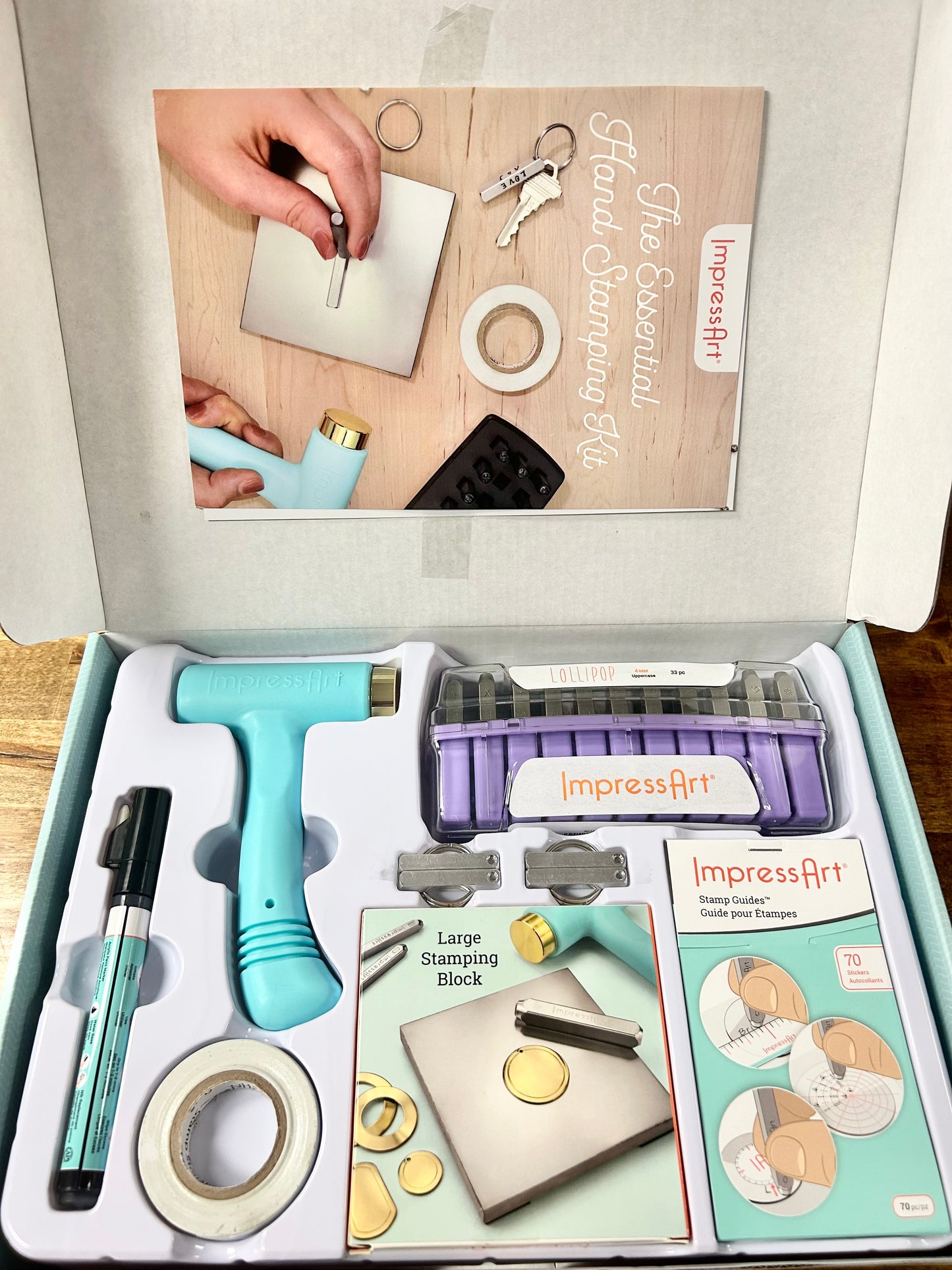 ImpressArt craft kit with tools and accessories on a wooden surface