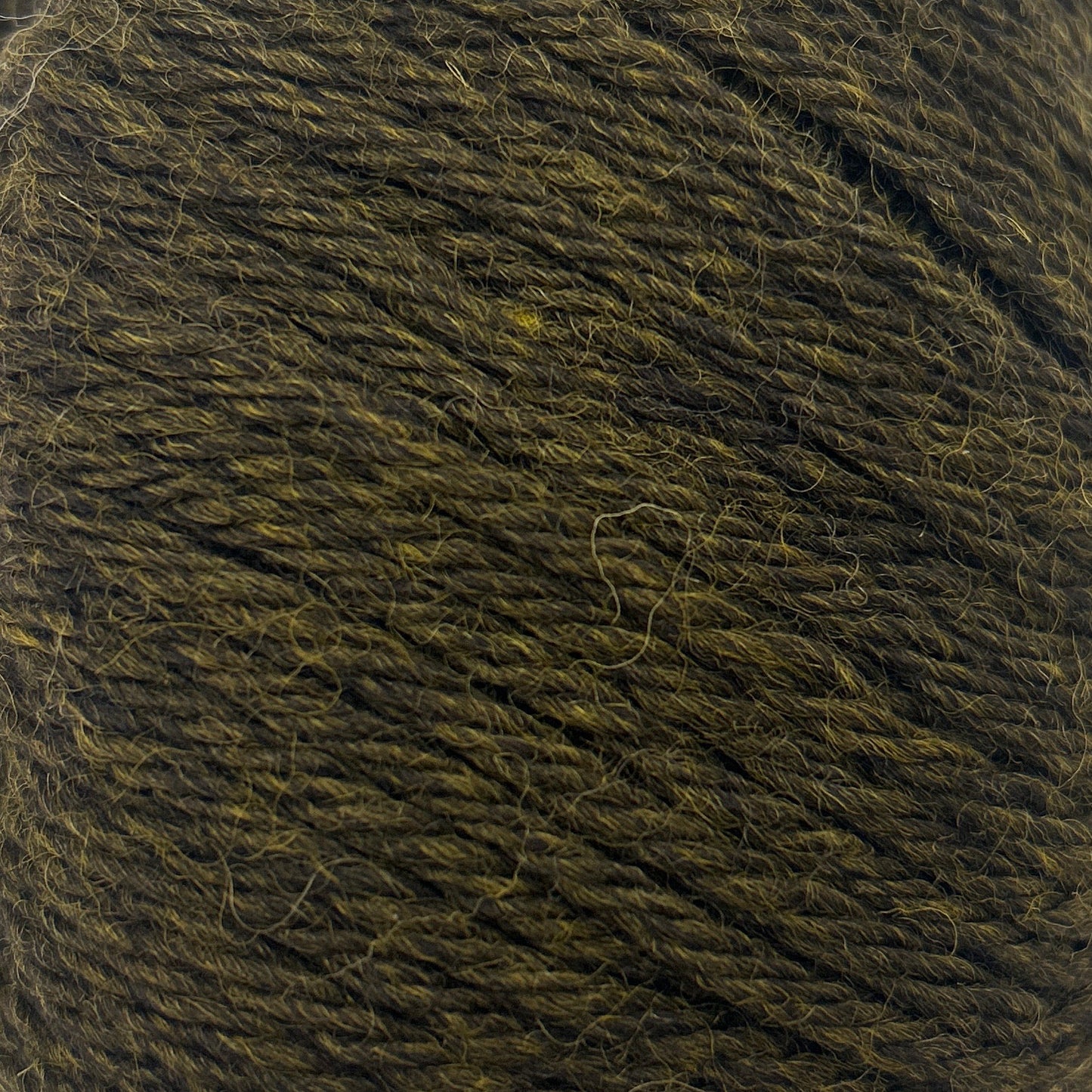 Ball of dark green yarn on a white background
