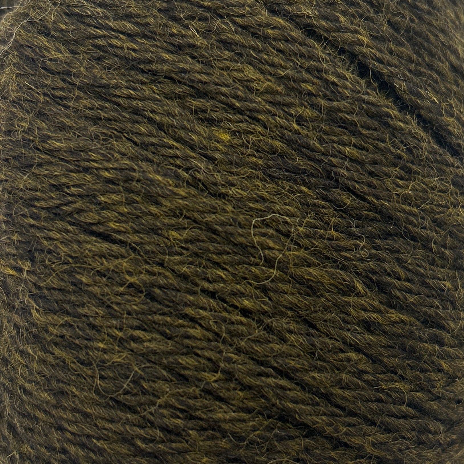 Ball of dark green yarn on a white background