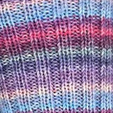 Close-up of striped fabric with pink, blue, and purple colors.