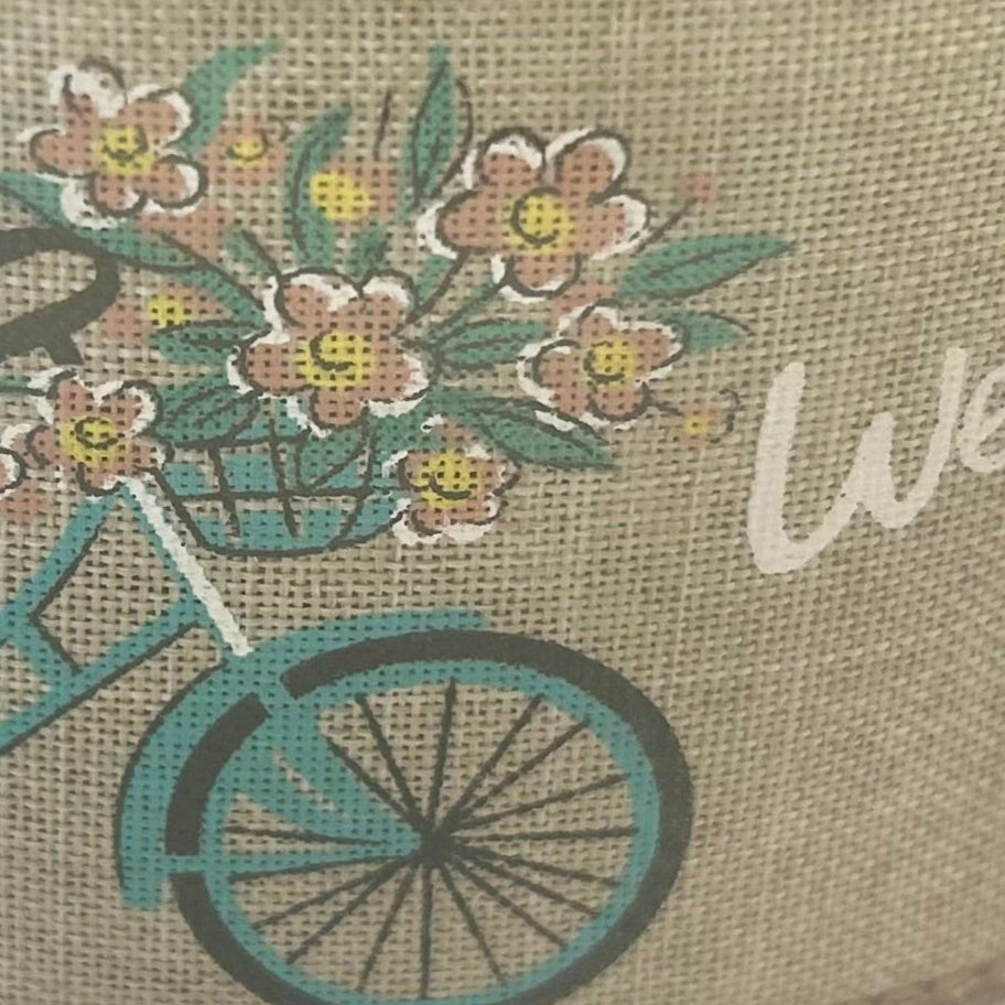 Bicycle with flower basket on a textured fabric background